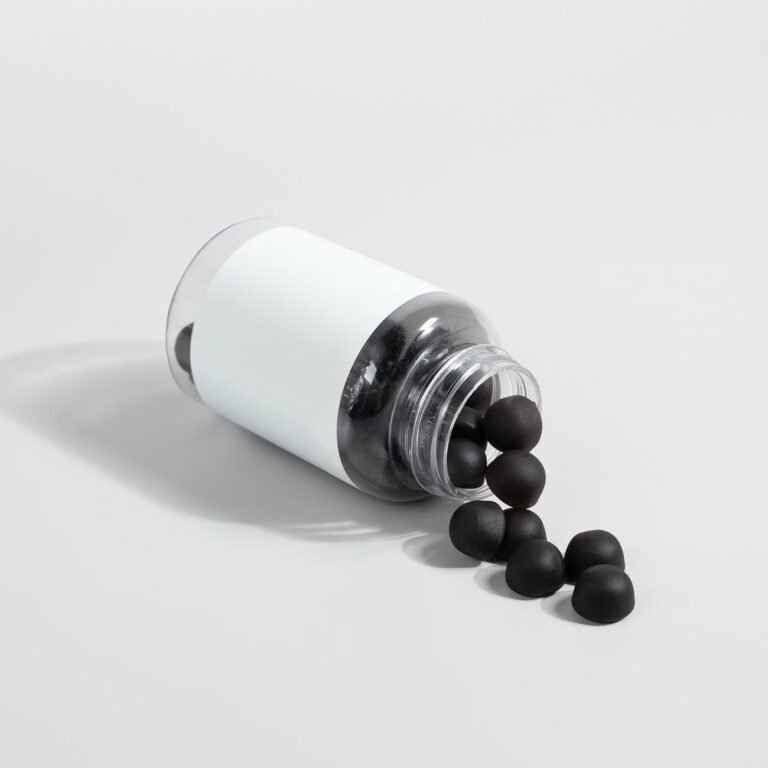 close up shot of black supplement gummies on white surface